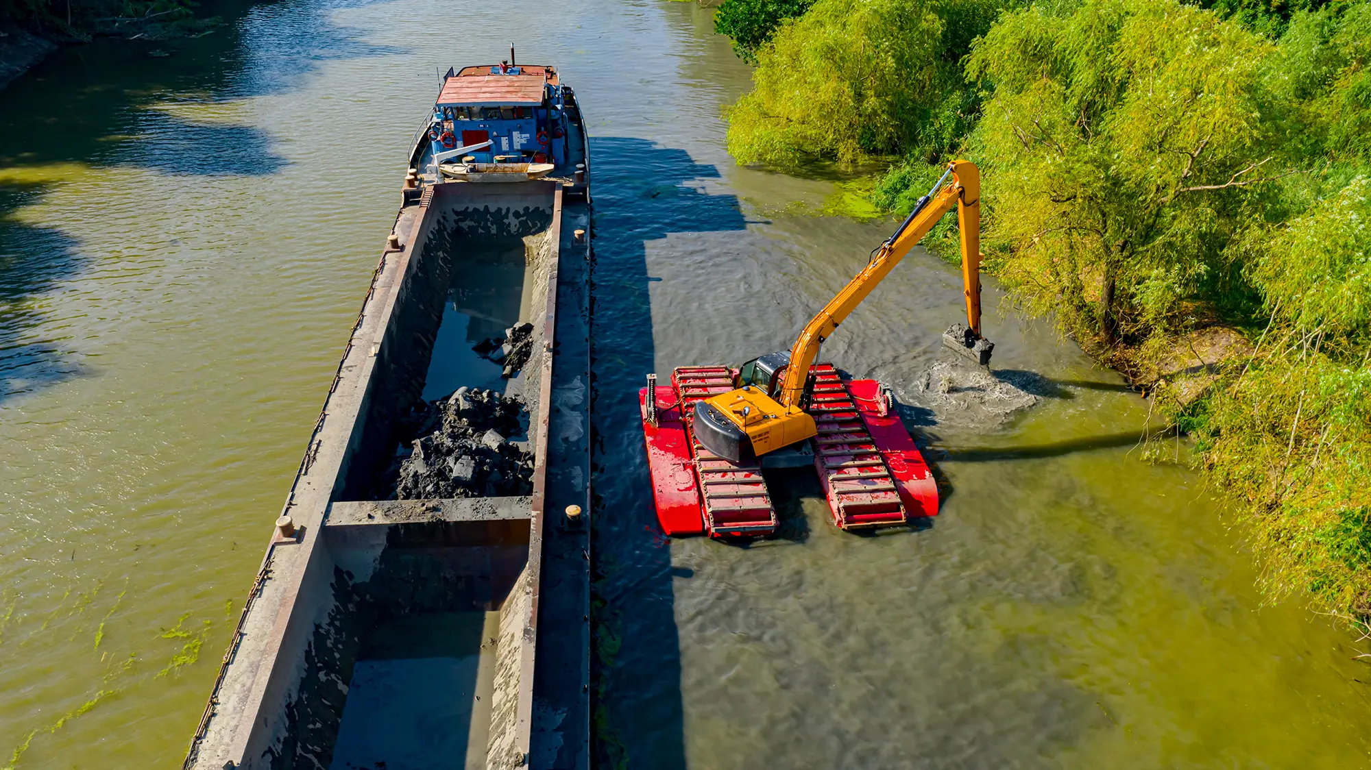 Canal is being dredged by excavator