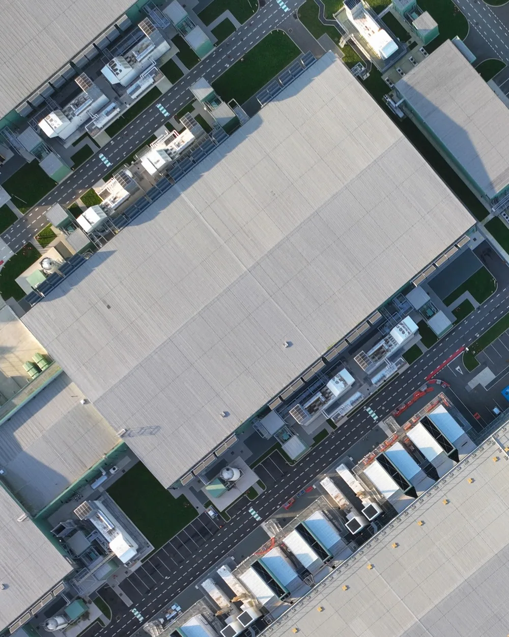 Aerial shot of grey roofs of large commercial factory buildings.