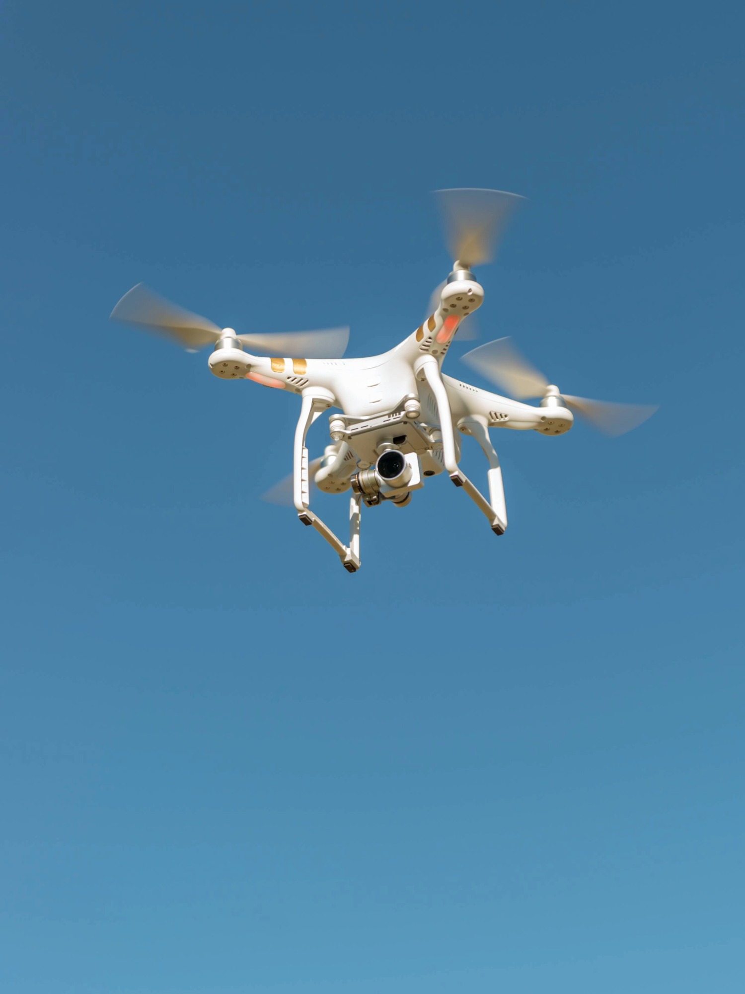 A drone completing a survey against a clear blue sky.