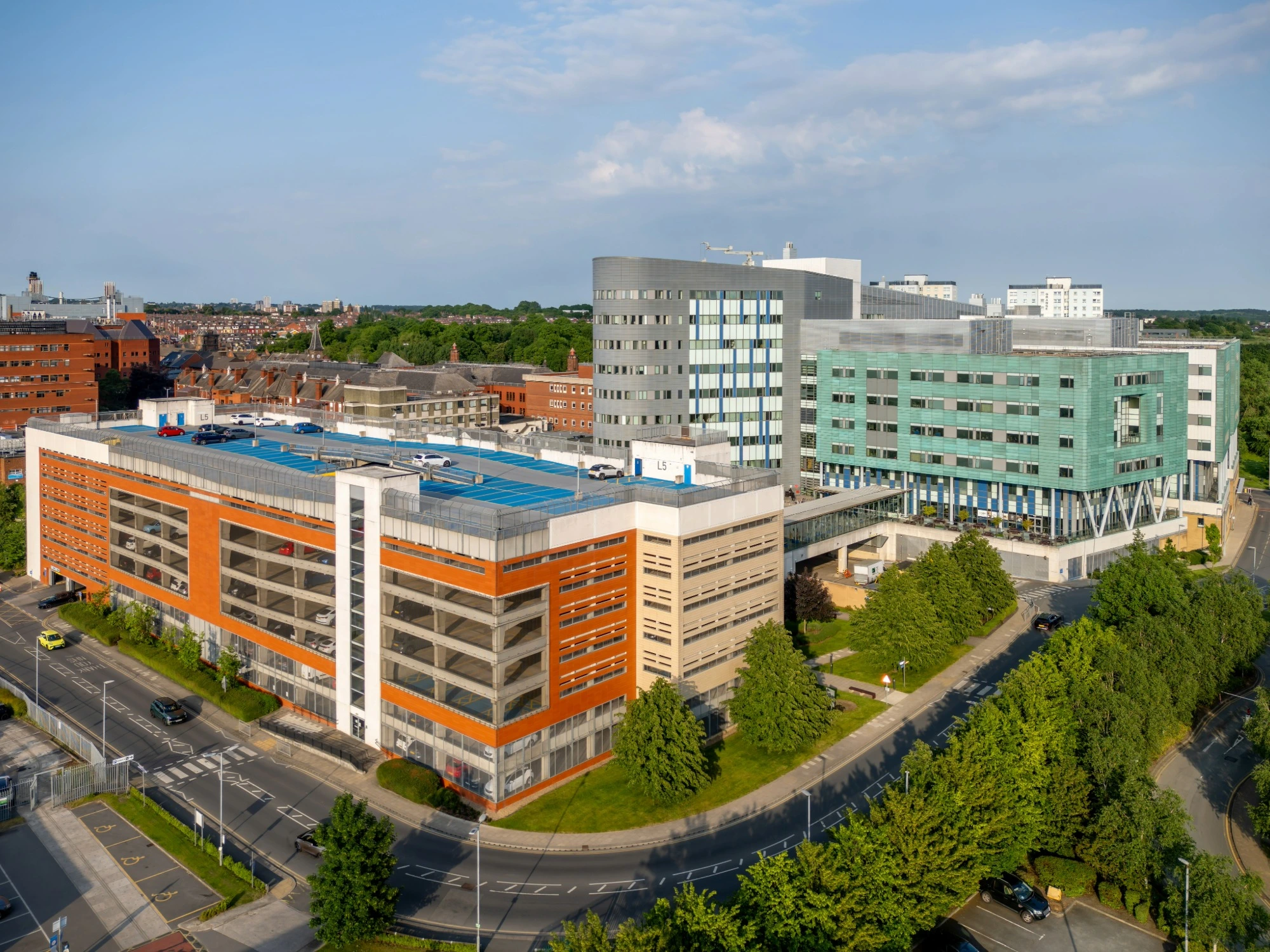 A UK healthcare building surrounded by a road and trees.