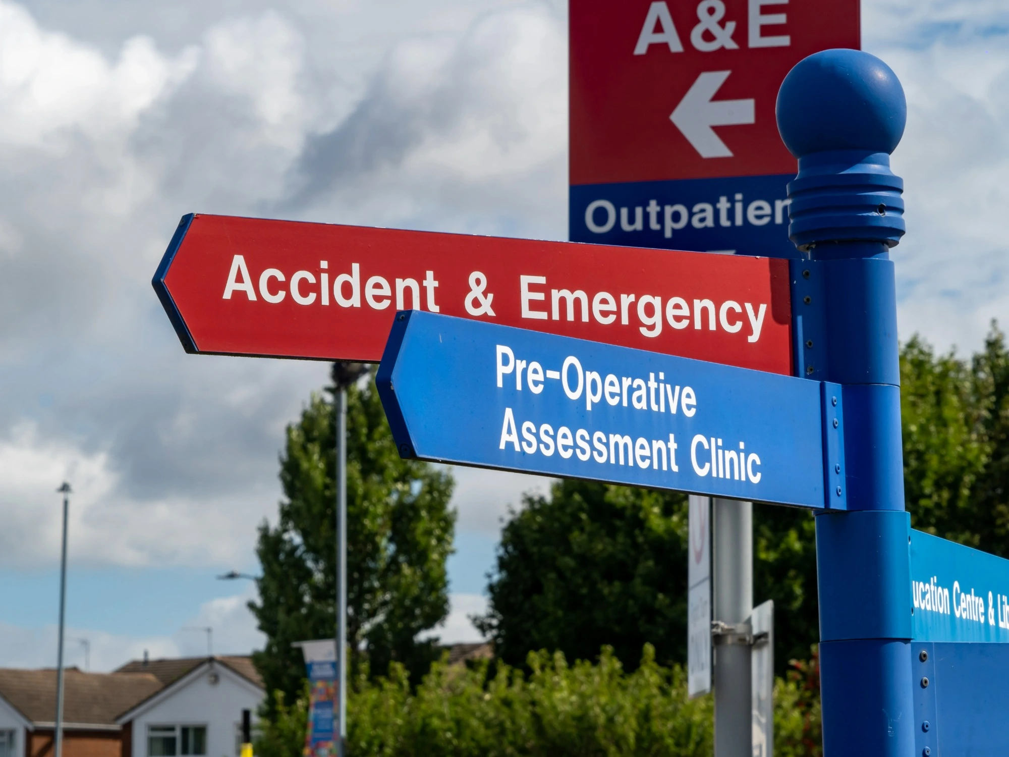 Signs outside an A&E building directing to different departments.