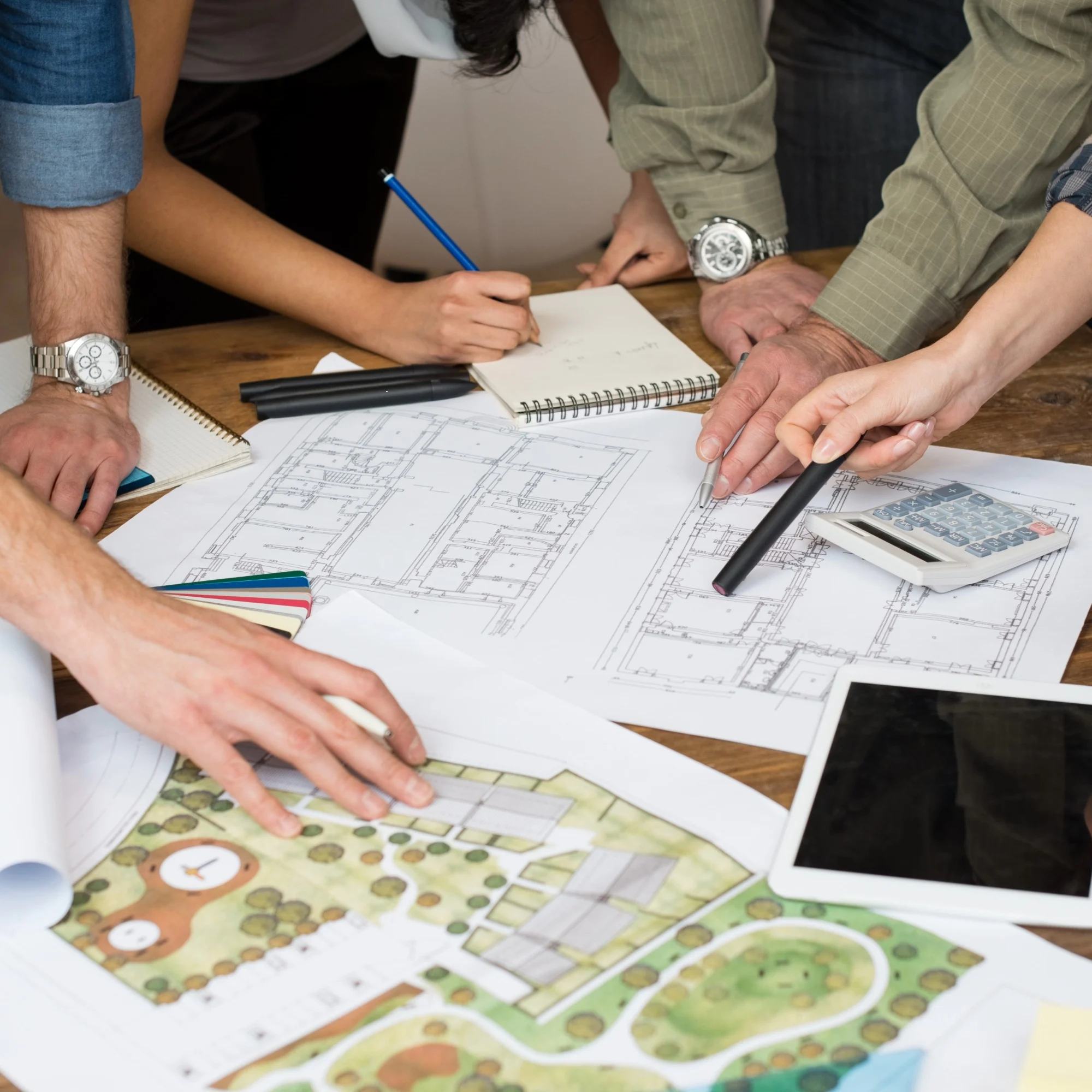 A group of architects and designers gathered around building plans.