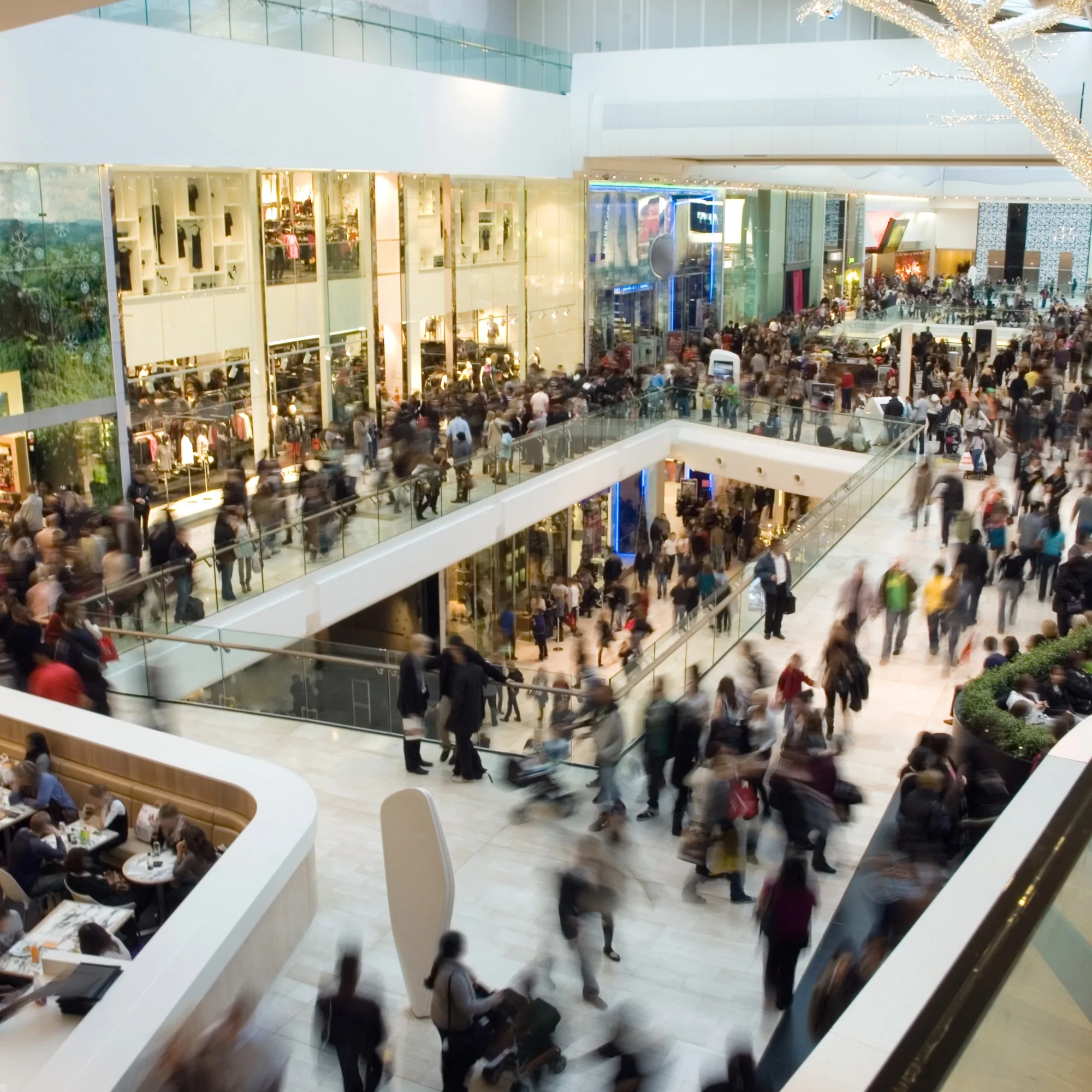 A busy shopping centre with large crowds moving around.