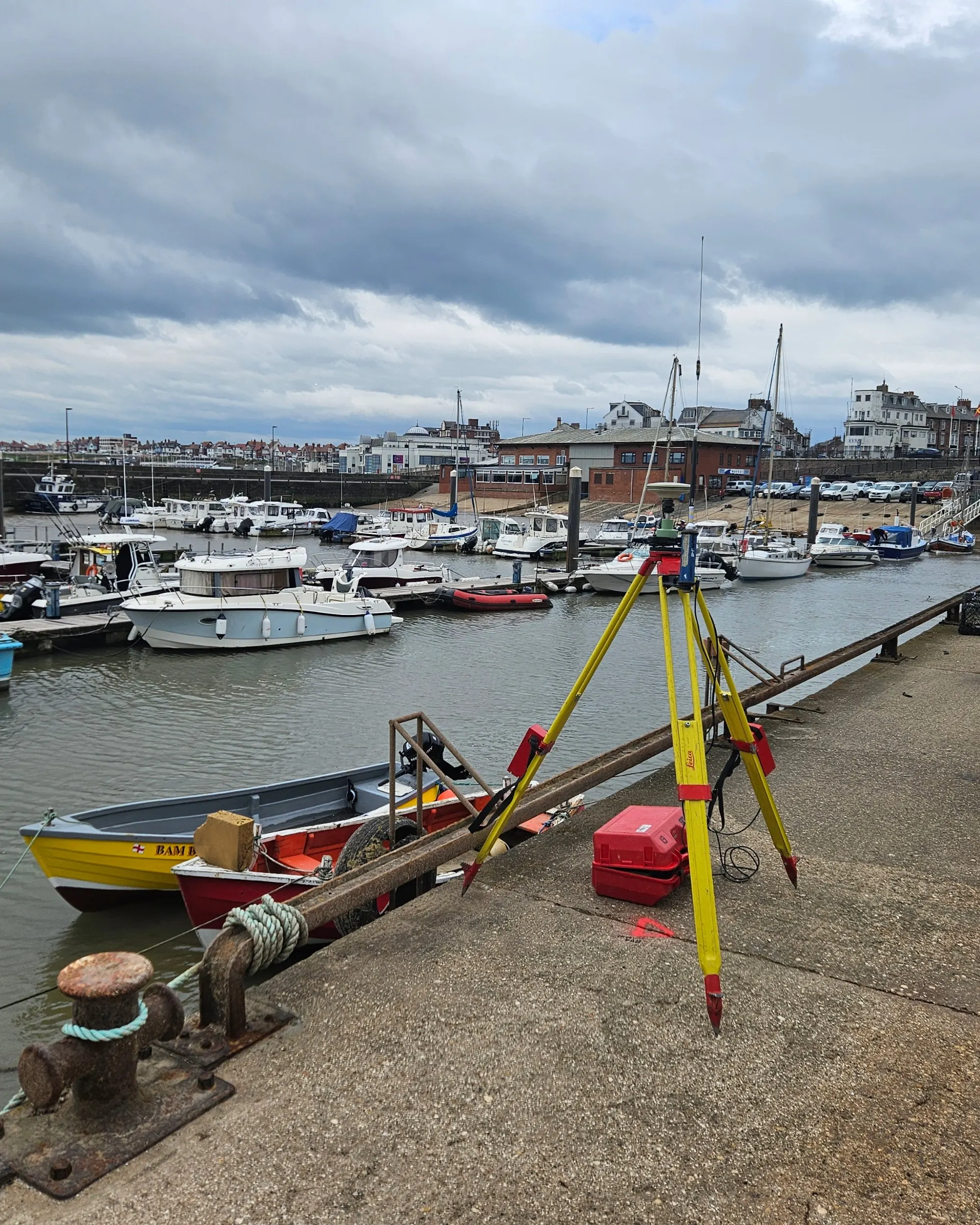 A piece of surveying equipment standing on a dock.
