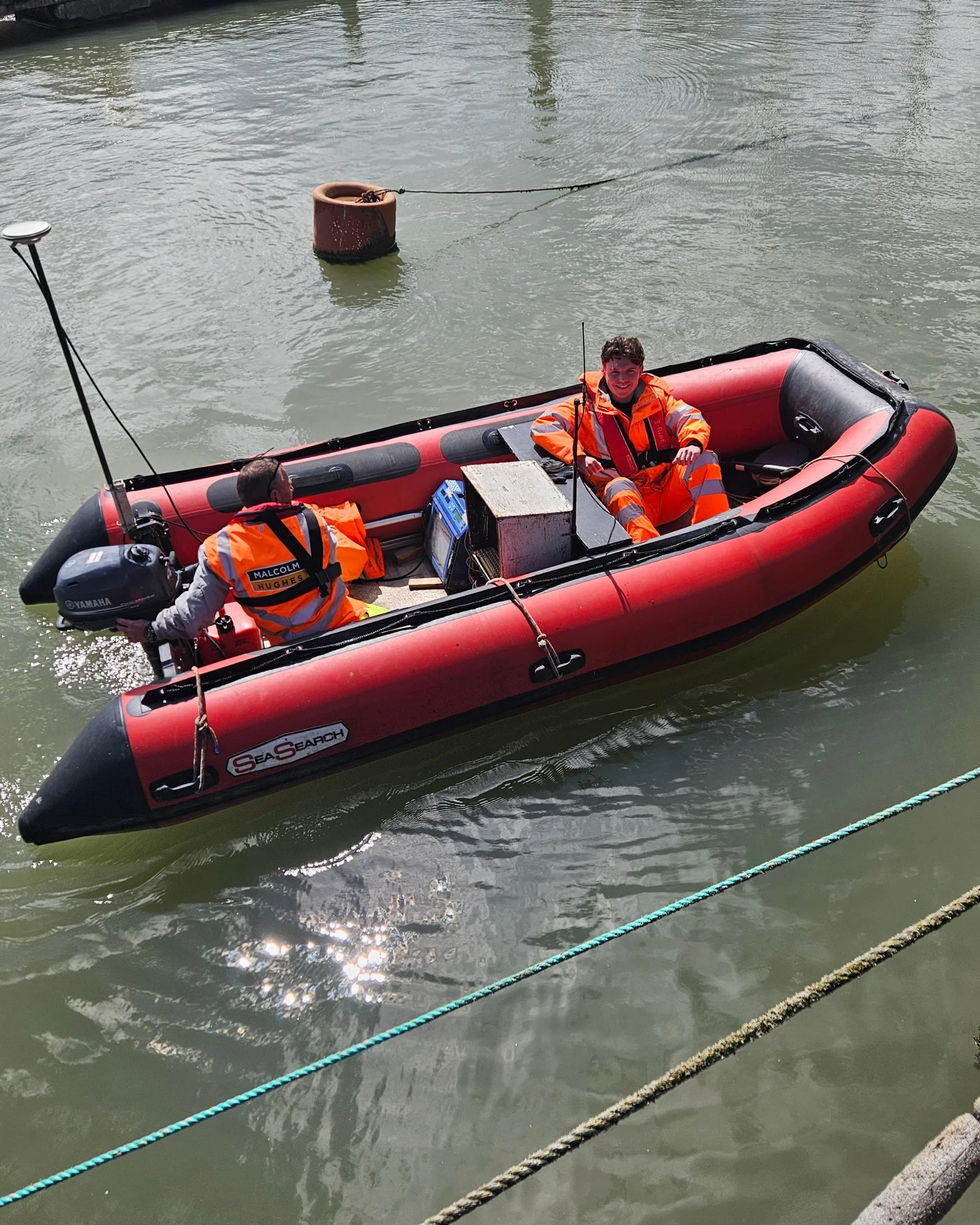 The Academy Geomatics team in a small red boat.